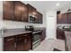 Well-lit kitchen features dark wood cabinets, stainless steel appliances and granite countertops at 16632 Sunburst Lake St, Wimauma, FL 33598
