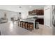 Open kitchen design with dark wood cabinets, granite countertops, island with seating and stainless steel appliances at 16632 Sunburst Lake St, Wimauma, FL 33598
