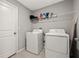 Functional laundry room equipped with a washer, dryer, and storage shelves for laundry essentials at 16632 Sunburst Lake St, Wimauma, FL 33598