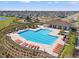 Aerial view of the community pool and recreation area, with ample lounge seating, a playground and clubhouse at 16632 Sunburst Lake St, Wimauma, FL 33598