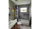 Updated bathroom features a shower and bathtub with gray tile and modern fixtures at 17430 Spring Valley Rd, Dade City, FL 33523