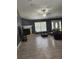 Open living room with tile floors, a fireplace, and a ceiling fan at 17430 Spring Valley Rd, Dade City, FL 33523