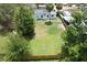 Large backyard enclosed by a wood fence, featuring a grassy lawn with scattered trees at 1762 Fulton Ave, Clearwater, FL 33755