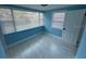 Well-lit room with tile flooring, two windows, and a white door, ready for personalization at 1762 Fulton Ave, Clearwater, FL 33755