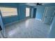 Bedroom featuring tile flooring, two windows for natural light, ceiling fan, and blue walls at 1762 Fulton Ave, Clearwater, FL 33755