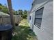 Side view of property featuring grass area, a side fence, and hose at 1762 Fulton Ave, Clearwater, FL 33755