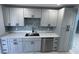 Bright kitchen featuring white cabinets, stone countertop, and stainless steel appliances at 1762 Fulton Ave, Clearwater, FL 33755
