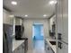 Well-lit kitchen showcasing grey cabinets, stone countertops, and stainless steel appliances at 1762 Fulton Ave, Clearwater, FL 33755