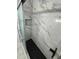 Modern shower features frameless glass doors, black fixtures, and black honeycomb floor tiles at 1762 Fulton Ave, Clearwater, FL 33755