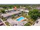 Aerial view featuring a community pool with condos, parking lots, and nearby shops at 1799 N Highland Ave # 3, Clearwater, FL 33755