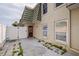 Backyard with concrete patio, white privacy fence, gate to alley, and the building's exterior at 1799 N Highland Ave # 3, Clearwater, FL 33755