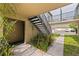 Exterior view of a condo complex featuring black iron stairs, green landscape, and ample parking at 1799 N Highland Ave # 3, Clearwater, FL 33755