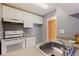 Galley kitchen with white appliances, cabinetry, laminate countertop and stainless steel sink at 1799 N Highland Ave # 3, Clearwater, FL 33755