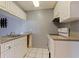 Galley kitchen features white cabinetry and white appliances at 1799 N Highland Ave # 3, Clearwater, FL 33755