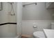 Bathroom featuring shower, toilet, wainscotting, and towel rack at 1828 Foxhunt Dr # A, Sun City Center, FL 33573
