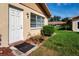 Beige home exterior featuring a white door, window with bars, and landscaping at 1828 Foxhunt Dr # A, Sun City Center, FL 33573
