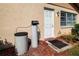 Beige home exterior featuring a white door, window with bars, and landscaping at 1828 Foxhunt Dr # A, Sun City Center, FL 33573