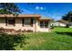 Back exterior of home with red shutters and a screened in porch on green grass at 1828 Foxhunt Dr # A, Sun City Center, FL 33573
