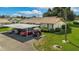 Exterior of home with three parked cars and a golf cart under a carport on green grass at 1828 Foxhunt Dr # A, Sun City Center, FL 33573