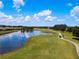 Scenic golf course view features a pond, winding path, and well-manicured green spaces on a sunny day at 1828 Foxhunt Dr # A, Sun City Center, FL 33573