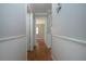 Hallway featuring hardwood floors and neutral paint leads to bedrooms at 1828 Foxhunt Dr # A, Sun City Center, FL 33573