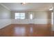 Spacious living room featuring wood floors, fresh paint, and a bright front door at 1828 Foxhunt Dr # A, Sun City Center, FL 33573