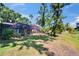 Backyard of a home with a screened pool area surrounded by lush greenery, enhancing privacy and beauty at 1905 Horseshoe Dr, Plant City, FL 33566