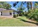 Backyard view features the home, landscaping, and a glimpse into the screened-in pool area, blending nature and living at 1905 Horseshoe Dr, Plant City, FL 33566