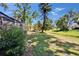 A backyard offers a view of the screened pool area nestled among the trees and landscaped grounds at 1905 Horseshoe Dr, Plant City, FL 33566