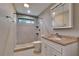 Beautifully tiled bathroom with tiled shower and vanity with sink and storage at 1905 Horseshoe Dr, Plant City, FL 33566