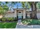 Charming home exterior featuring a light blue front door, manicured landscaping, and a large shade tree at 1905 Horseshoe Dr, Plant City, FL 33566