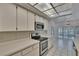 Well-lit kitchen with stainless appliances, bright white countertops, and tile flooring at 1905 Horseshoe Dr, Plant City, FL 33566