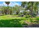 Green backyard featuring pond, waterfall, lush tropical landscaping and water views at 191 Banyan Bay Dr, St Petersburg, FL 33705