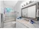 Cozy bathroom with decorative mirror, glass shower, and marble countertops at 191 Banyan Bay Dr, St Petersburg, FL 33705
