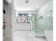 Beautiful bathroom featuring marble tile, glass shower, double vanity, and soaking tub at 191 Banyan Bay Dr, St Petersburg, FL 33705