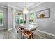 Bright dining area with a stylish marble table, chandelier, and views of the backyard at 191 Banyan Bay Dr, St Petersburg, FL 33705