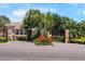 Elegant community entrance with lush tropical landscaping, mature palm trees, and vibrant flower beds at 191 Banyan Bay Dr, St Petersburg, FL 33705