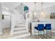 Charming foyer featuring stairs, a beverage bar, and blue bar stools for a stylish welcoming space at 191 Banyan Bay Dr, St Petersburg, FL 33705