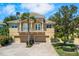 Inviting two-story home with a balcony, three-car garage, well-manicured landscaping, and a beautiful brick driveway at 191 Banyan Bay Dr, St Petersburg, FL 33705
