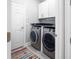 Laundry room featuring modern washer and dryer, with overhead cabinets at 191 Banyan Bay Dr, St Petersburg, FL 33705