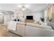Bright living room with a large sectional sofa, ceiling fan, and staircase with white railing at 191 Banyan Bay Dr, St Petersburg, FL 33705