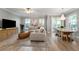Spacious living room with hardwood floors, a large couch, a dining table, and natural light from the windows at 191 Banyan Bay Dr, St Petersburg, FL 33705