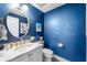 Stylish powder room with textured blue walls, gold fixtures, and a marble countertop at 191 Banyan Bay Dr, St Petersburg, FL 33705