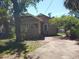 Tan home with a front yard and driveway with a concrete walkway leading to the front door at 1924 30Th S St, St Petersburg, FL 33712