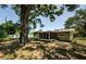 Expansive backyard featuring a screened-in porch, lush greenery, and mature trees providing a peaceful retreat at 1926 Fairway W Cir, Dunedin, FL 34698