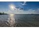 A sunny beach view of water and sand with sun rays in the sky at 1926 Fairway W Cir, Dunedin, FL 34698