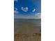 Sunlit image of a beach and clear water with few clouds in the sky at 1926 Fairway W Cir, Dunedin, FL 34698