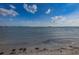 Water lapping onto the beach and sand on a sunny day with a beautiful sky at 1926 Fairway W Cir, Dunedin, FL 34698