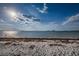 Beach view, showing water lapping at the shore on a sunny day at 1926 Fairway W Cir, Dunedin, FL 34698