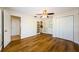 A bedroom with hardwood floors, a ceiling fan and closet space, offering comfort and style at 1926 Fairway W Cir, Dunedin, FL 34698